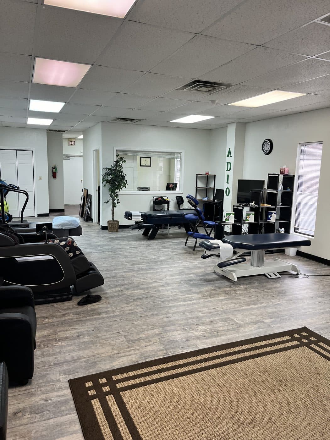 Open treatment floor at BioSpine Health and Wellness with adjustment tables, massage chairs, and rehabilitation equipment